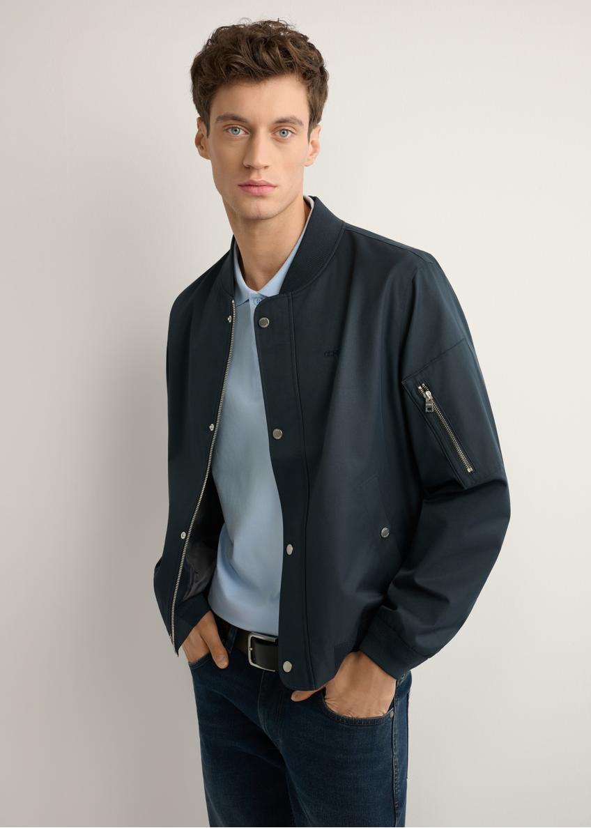 Granatowa przejściowa kurtka męska KURMT-0403-7D(W26), widok produktu z boku na modelu. Widoczna połowa sylwetki.