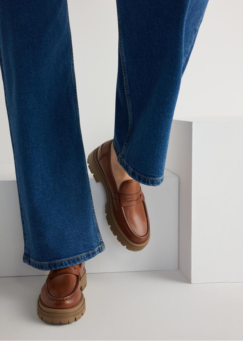 Skórzane mokasyny na platformie w kolorze koniaku BUTYD-1069-1F(W26), widok produktu od przodu na modelce, widoczna połowa sylwetki.