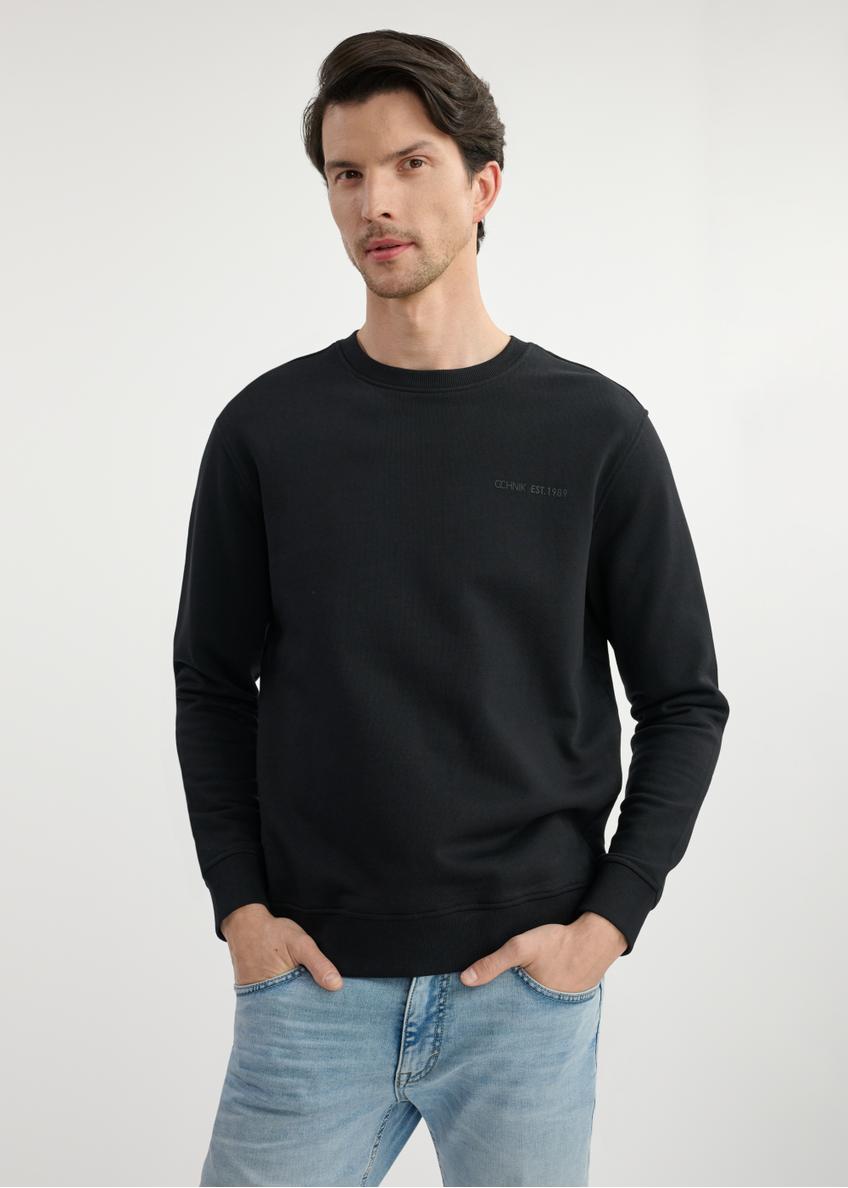 Czarna bluza męska bez kaptura BLZMT-0070-99(W25) - widok z przodu na modelu na białym tle. Widoczna połowa sylwetki. 