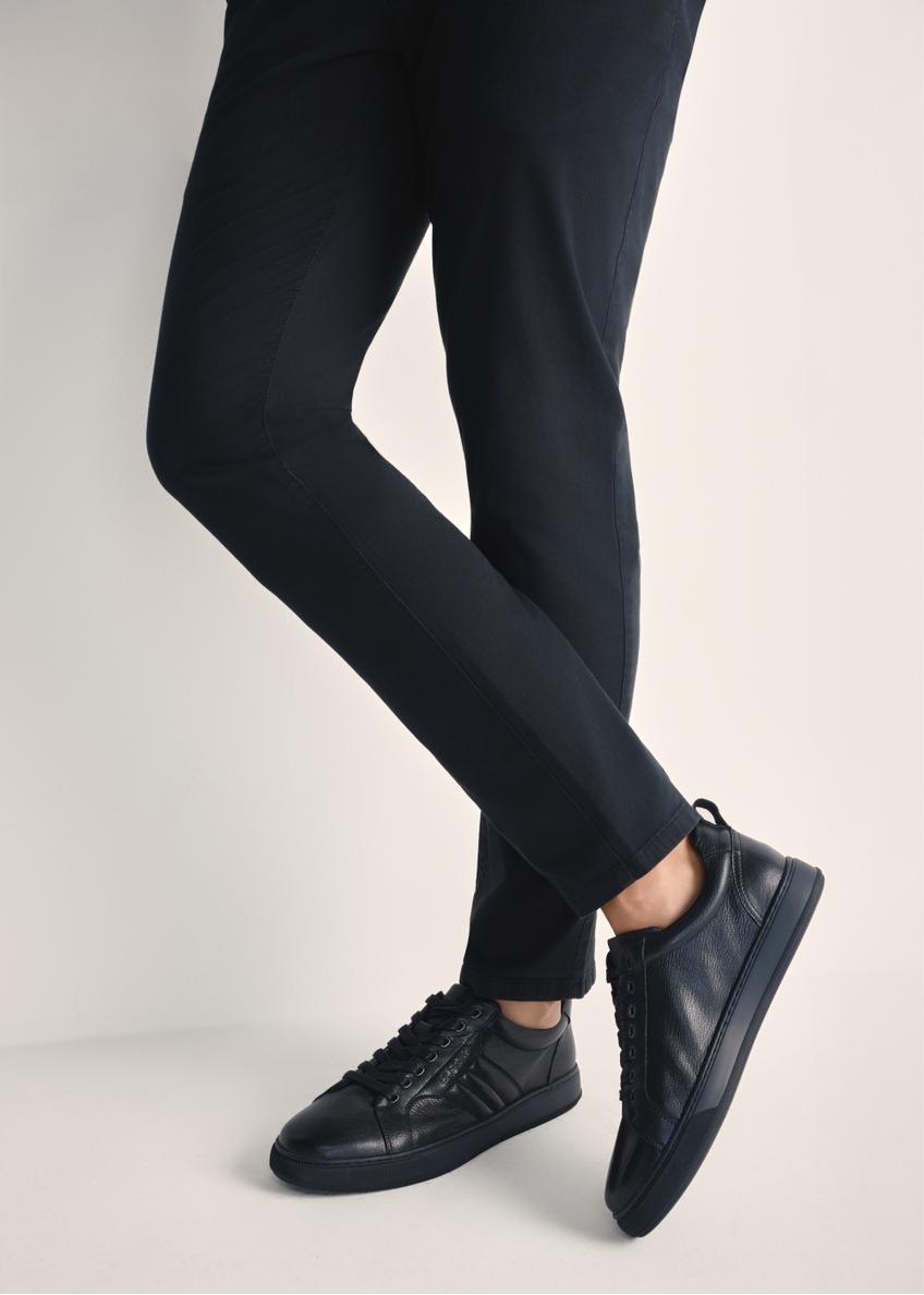 Czarne skórzane sneakersy męskie BUTYM-0465-99(Z25), widok produktu na stopach modela na jasnym tle.