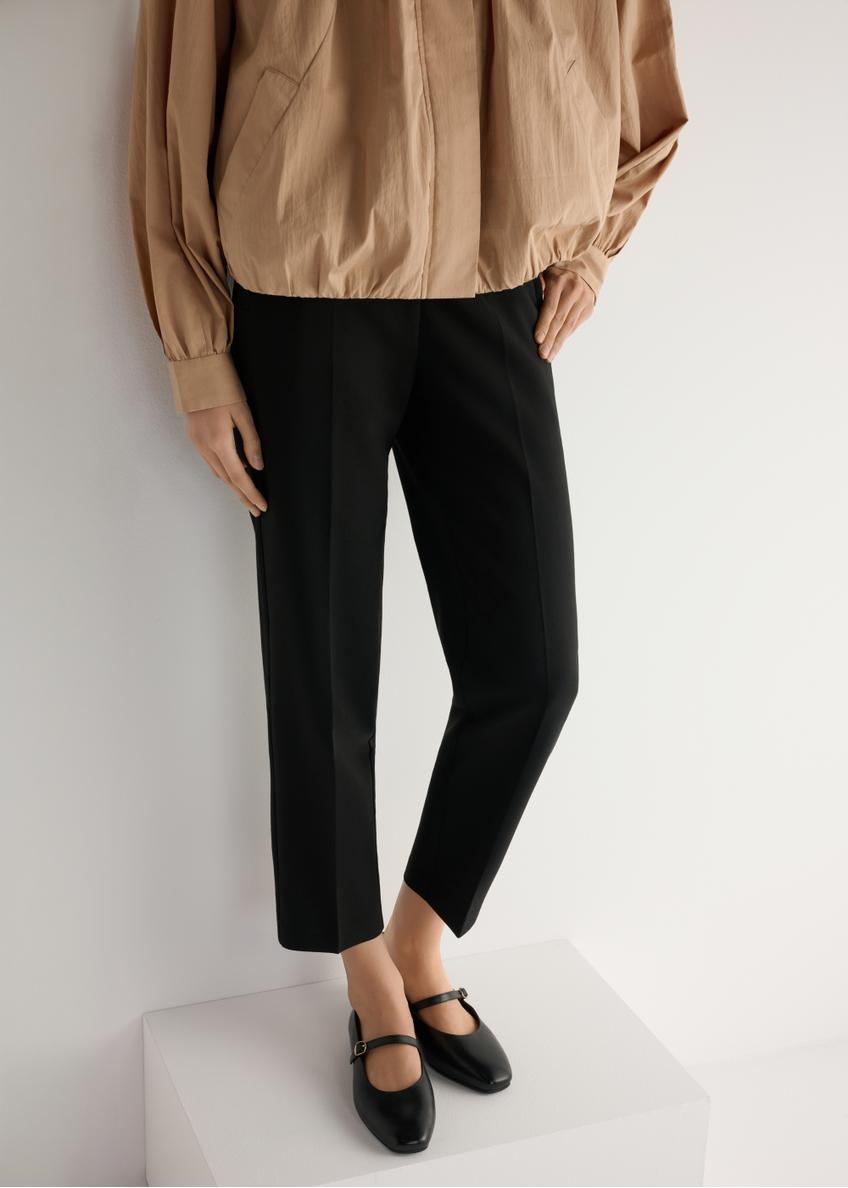 Czarne baleriny skórzane z paskiem BUTYD-1145-99(W25), widok produktu od przodu na modelce, widoczna połowa sylwetki.