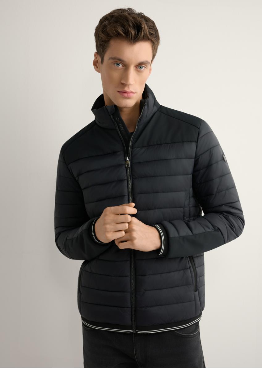 Czarna kurtka męska przejściowa KURMT-0358A-99(W26) - widok produktu z przodu, na modelu, na jasnym tle. Widoczna połowa sylwetki.