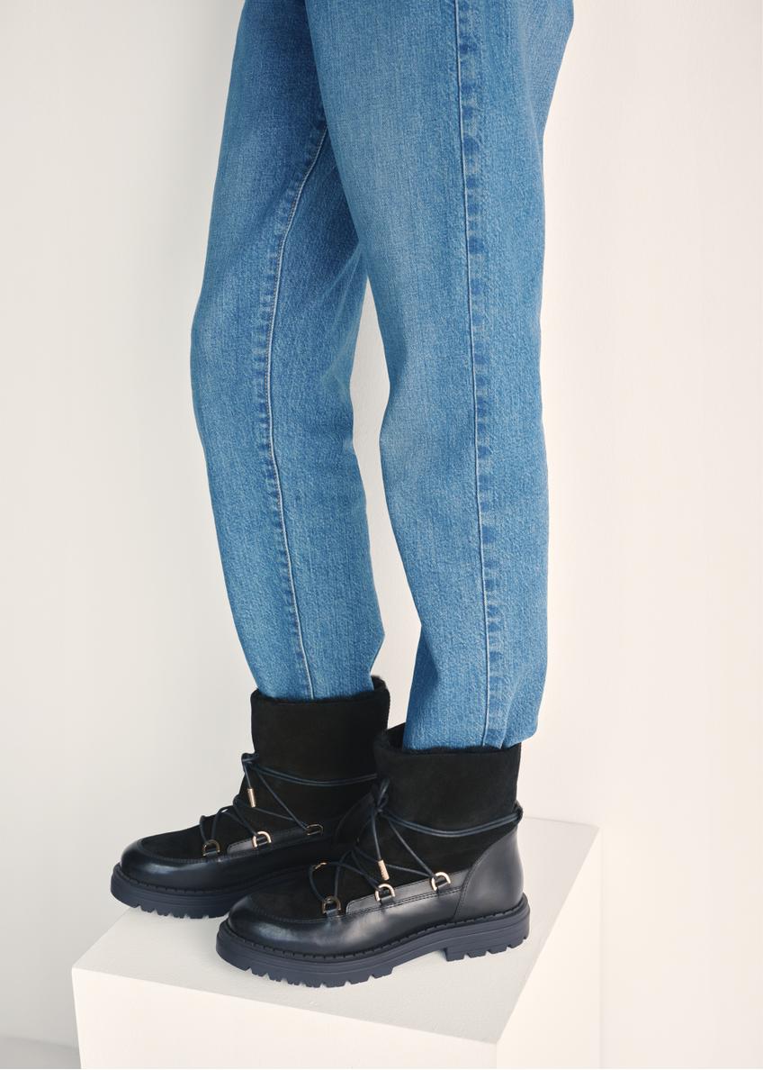 Czarne zamszowe śniegowce damskie BUTYD-1201-99(Z25) - widok produktu z boku na modelce na białym tle. Widoczna połowa sylwetki.