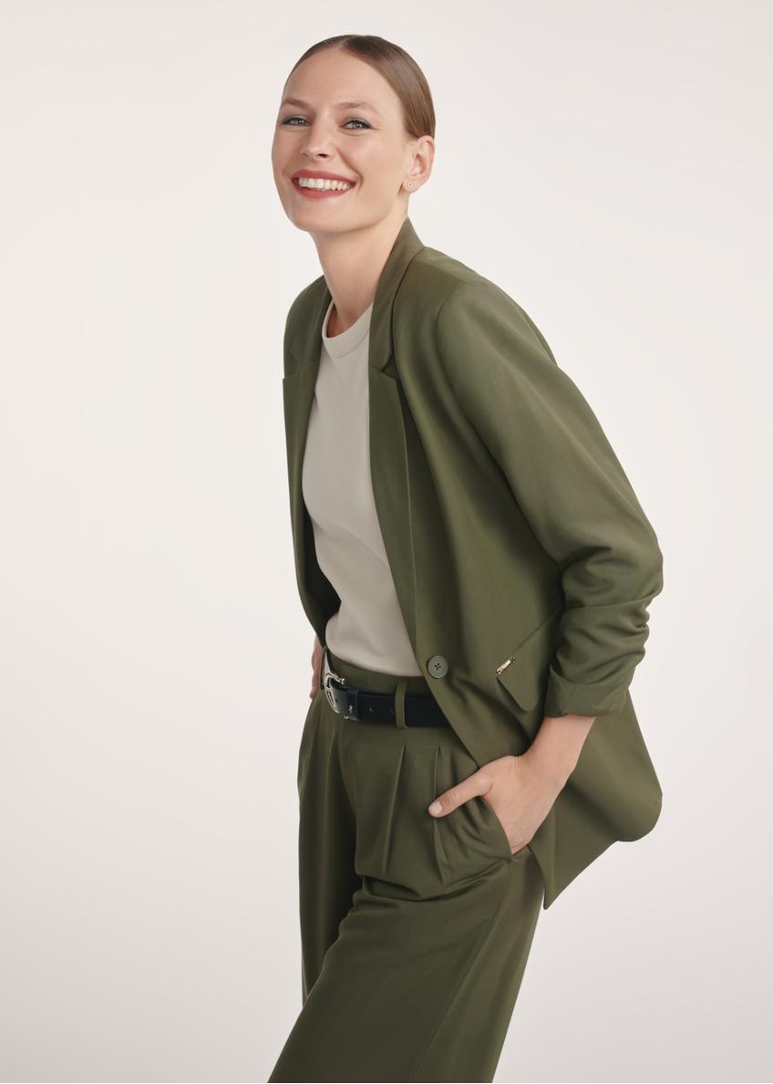 Marynarka damska w kolorze khaki ZAKDT-0043-55(Z25), widok produktu na modelce. Widoczna połowa sylwetki.