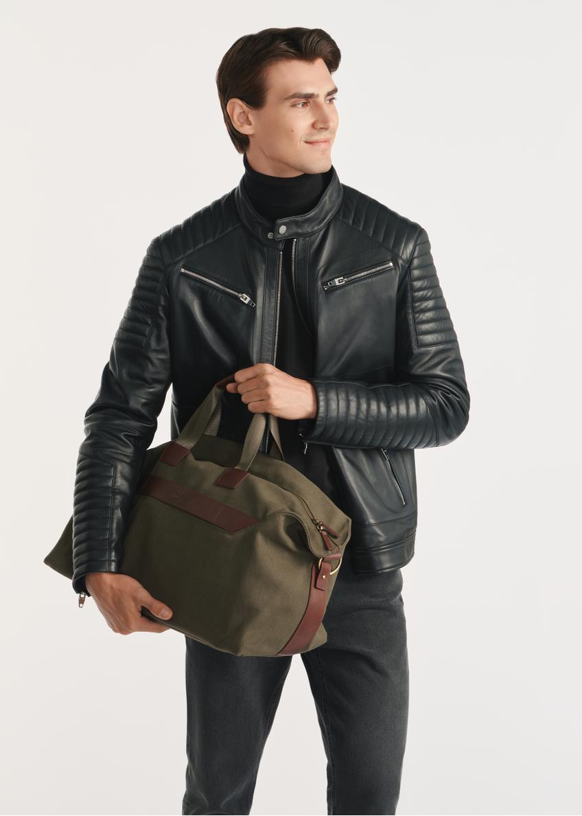 Torba podróżna w kolorze khaki TORMN-0372-55(Z25) - widok produktu na modelu, na białym tle. Widoczna sylwetka do kolan.